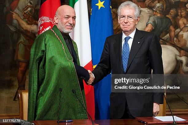 Afghan President Hamid Karzai and Italian Prime Minister shake hands after signing a bilateral agreement on cooperation and partnership, at Palazzo...