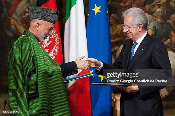 Afghan President Hamid Karzai and Italian Prime Minister shake hands after signing a bilateral agreement on cooperation and partnership, at Palazzo...