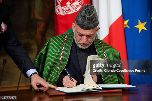Afghan President Hamid Karzai signes a bilateral agreement on cooperation and partnership during a meeting with Italian Prime Minister Mario Monti at...