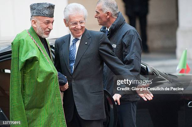 Italian Prime Minister Mario Monti welcomes Afghan President Hamid Karzai as he arrives to attend an official meeting to sign a bilateral agreement...