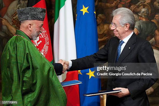 Afghan President Hamid Karzai and Italian Prime Minister shake hands after sign a bilateral agreement on cooperation and partnership, at Palazzo...