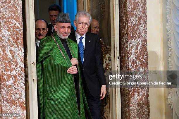 Afghan President Hamid Karzai and Italian Prime Minister Mario Monti arrive to attend a meeting to sign a bilateral agreement on cooperation and...