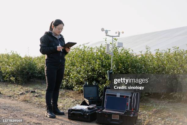 agricultural scientists record weather data at solar power station - indagini di clima foto e immagini stock