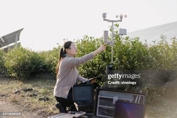 agricultural scientists record weather data at solar power station - meteorologist stock pictures, royalty-free photos & images