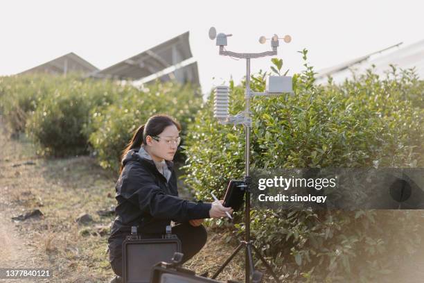 agricultural scientists record weather data at solar power station - meteorologist stock pictures, royalty-free photos & images