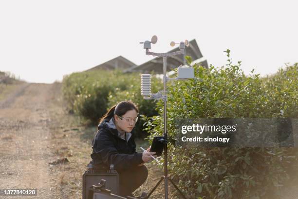 agricultural scientists record weather data at solar power station - meteorologist stock pictures, royalty-free photos & images