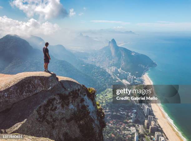 man standing on top of pedra da gavea rio de janeiro - ipanema beach stock pictures, royalty-free photos & images