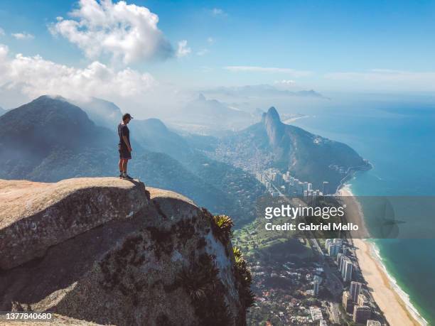 man standing on top of pedra da gavea rio de janeiro - tijuca stock-fotos und bilder