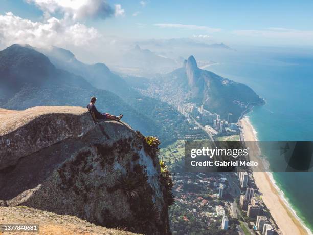 man sitting and looking the views over rio de janeiro - ipanema beach stock-fotos und bilder