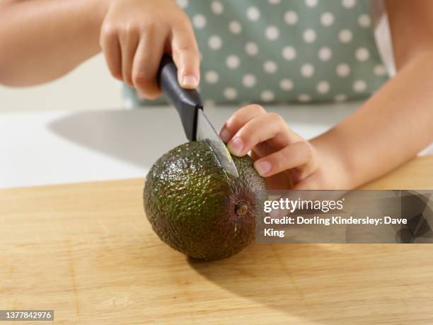 preparing an avocado - cutting avocado stockfoto's en -beelden