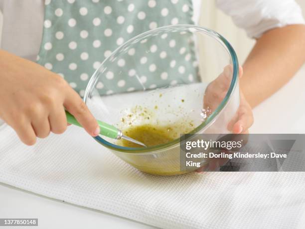 leafy green salad - making a simple salad dressing in a glass bowl (step 3 of 4) - vinaigrette dressing photos et images de collection