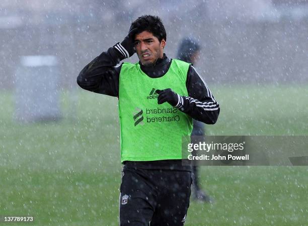 Luis Suarez of Liverpool looks unhappy as he is caught in a hail storm during a team training session at Melwood Training Ground on January 27, 2012...