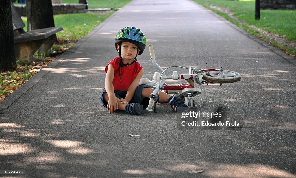 Little boy falling off bicycle