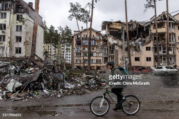 Man rides his bike past destroyed buildings on March 03, 2022 in Irpin, Ukraine. Russia continues assault on Ukraine's major cities, including the...