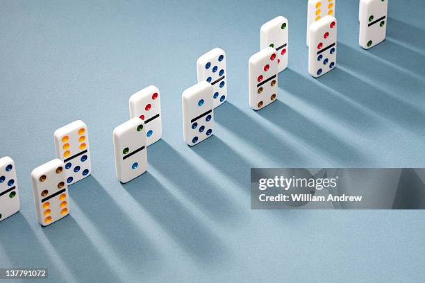 dominoes lined up, casting shadow - dominó imagens e fotografias de stock