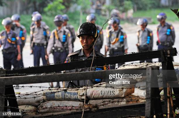 Policemen man a check-point set up across the road leading to Myanmar's opposition leader Aung San Suu Kyi's house in Yangon on November 13, 2010....