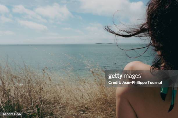 shirtless woman relaxing by the sea - day dreaming in brittany - off shoulder stock pictures, royalty-free photos & images