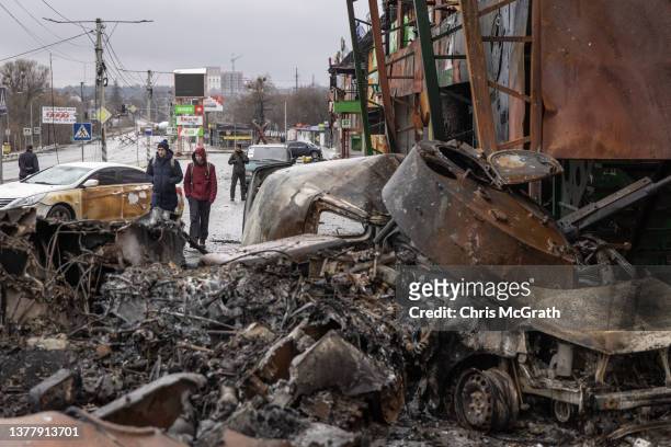 People walk past a destroyed Russian military vehicle at a frontline position on March 03, 2022 in Irpin, Ukraine. Russia continues assault on...