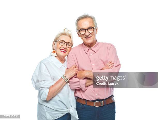 smiling retired senior couple standing together - couple studio stockfoto's en -beelden