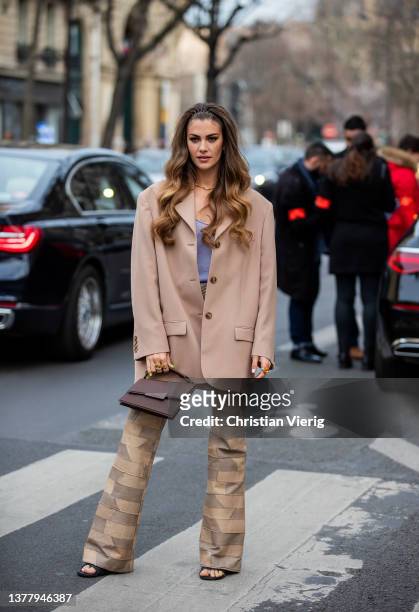 Clara Berry is seen wearing beige brown checkered flared pants, brown Acne bag, beige blazer, grey top, heels outside Acne during Paris Fashion Week...