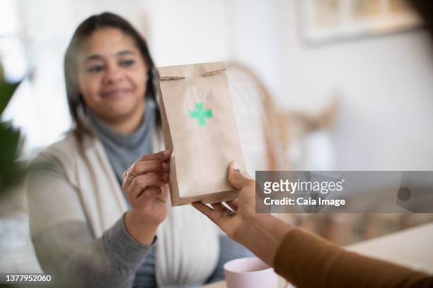 woman reaching for prescription pharmacy bag - drug delivery fotografías e imágenes de stock