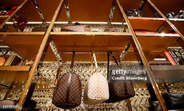 Louis Vuitton bags hang on display inside the company's new "Etoile" store, operated by LVMH Moet Hennessy Louis Vuitton SA, in a former cinema in...