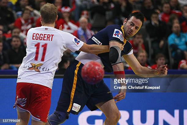 Anders Eggert Jensen of Denmark defends against Iker Romero of Spain during the Men's European Handball Championship first semi final match between...