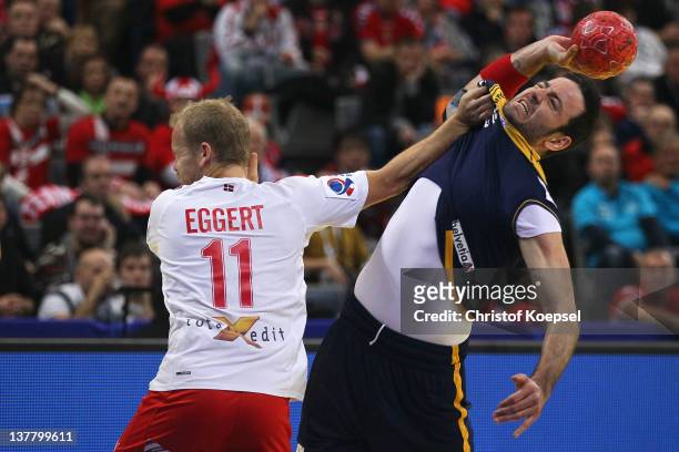 Anders Eggert Jensen of Denmark defends against Iker Romero of Spain during the Men's European Handball Championship first semi final match between...