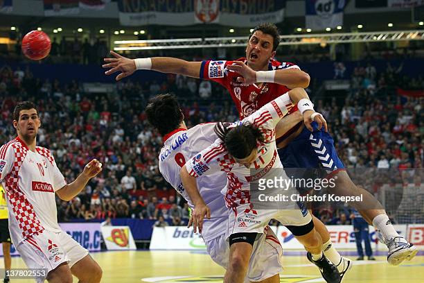 Marko Kopljar and Ivan Cupic of Croatia defend against Momir Ilic of Serbia during the Men's European Handball Championship second semi final match...