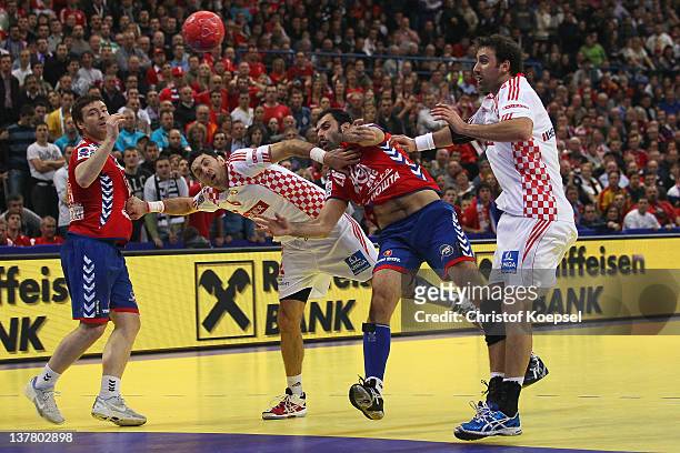 Ivan Stankovic of Serbia scores a goal against Blazenko Lackovic of Croatia and Igor Vori of Croatia during the Men's European Handball Championship...