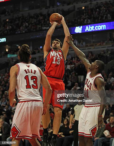 Mehmet Okur of the New Jersey Nets puts up a shot between Joakim Noah and Ronnie Brewer of the Chicago Bulls at the United Center on January 23, 2012...