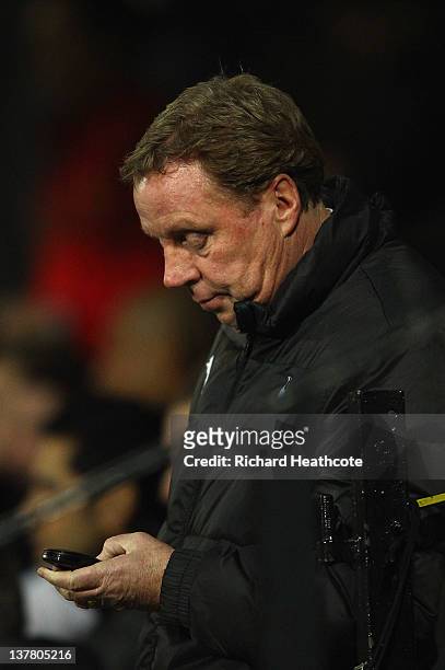 Manager Harry Redknapp of Spurs looks at his phone during the FA Cup Fourth Round match between Watford and Tottenham Hotspur at Vicarage Road on...
