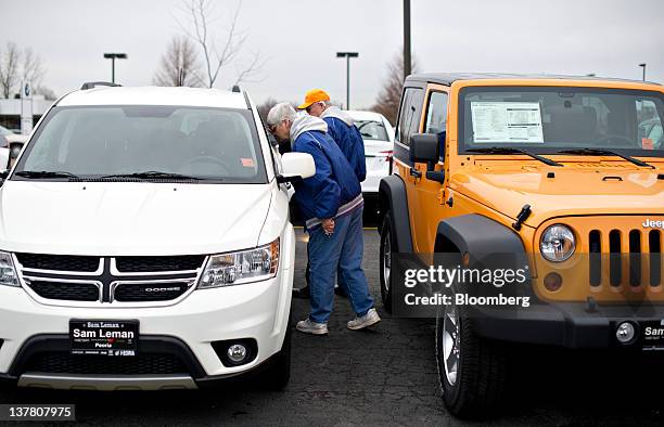 Jan Pippin and her husband Jerry look over a 2012 Dodge Journey on display at Sam Leman Chrysler, Dodge, Jeep in Peoria, Illinois, U.S., on Friday,...