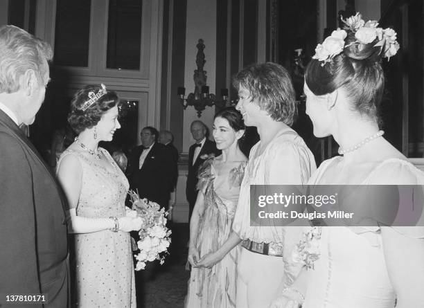 Queen Elizabeth II speaks to Margot Fonteyn and Rudolf Nureyev after a gala performance at Covent Garden to mark the 35th anniversary of Margot...