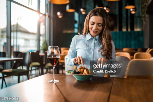 happy woman having lunch and wine in a restaurant. - eating yummy stock pictures, royalty-free photos & images
