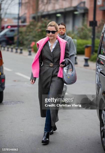 Guest is seen wearing grey belted coat, silver bag outside Coperni during Paris Fashion Week - Womenswear F/W 2022-2023 on March 03, 2022 in Paris,...