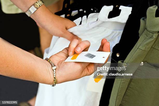 price tag with hands. color image - garment tag stock pictures, royalty-free photos & images