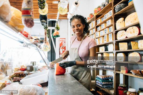 grocery store owner serving customer orders - delicatessen stock pictures, royalty-free photos & images