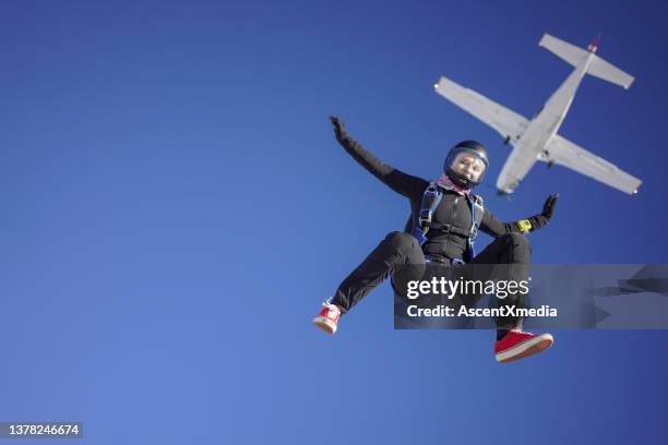 weibliche fallschirmspringerin fällt aus flugzeug, luftflug - flugzeug gurt stock-fotos und bilder