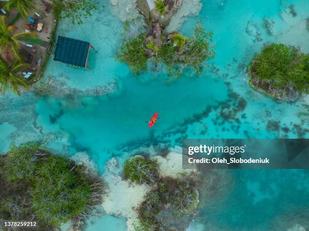 vue aérienne d’un canoë rouge sur la lagune de bacalar au mexique - lagon photos et images de collection