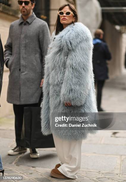 Guest is seen wearing a faux light blue fur coat and pink sunglasses outside the Roger Vivier presentation during Paris Fashion Week A/W 2022 on...
