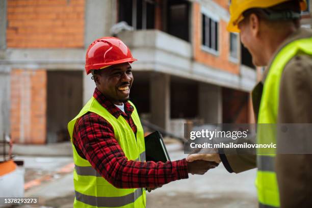 handshake and smile - construction contract stock pictures, royalty-free photos & images