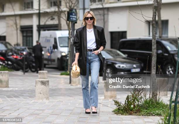 Lisa Aiken is seen wearing a black jacket, white shirt, blue jeans and gold bag outside the Chloe show during Paris Fashion Week A/W 2022 on March...