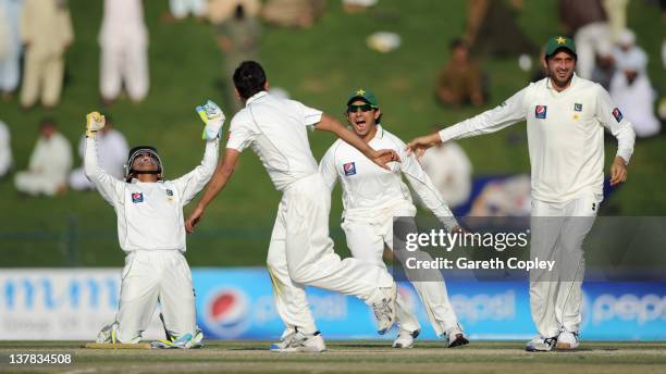 Abdur Rehman of Pakistan celebrates with Adnan Akmal, Saeed Ajmal and Junaid Khan after dismissing James Anderson of England at Sheikh Zayed Stadium...