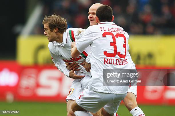 Marcel de Jong of Augsburg with team mates Tobias Werner and Sascha Moelders celebrates his team's first goal during the Bundesliga match between FC...