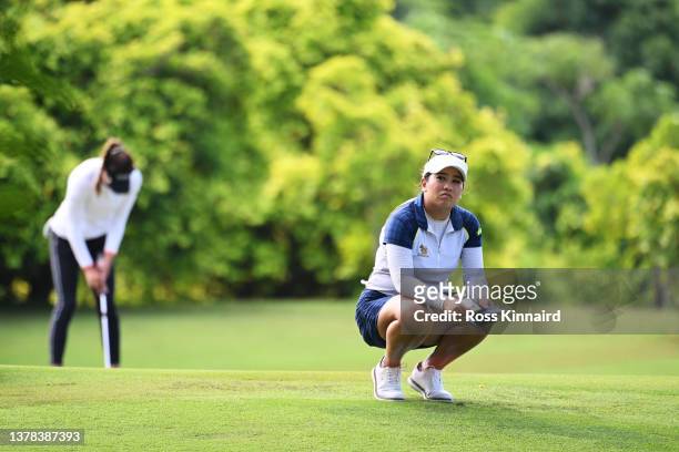Jasmine Suwannapura of Thailand reacts on the thirteenth green as Alison Lee of The United States putts in the background during the Second Round of...