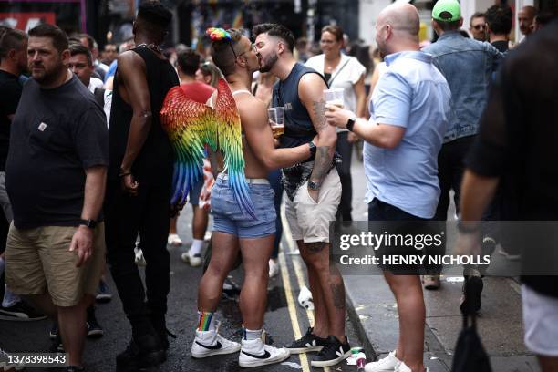 Couple kiss as people party in Soho following the of the annual Pride Parade, by members of the Lesbian, Gay, Bisexual and Transgender community, in...