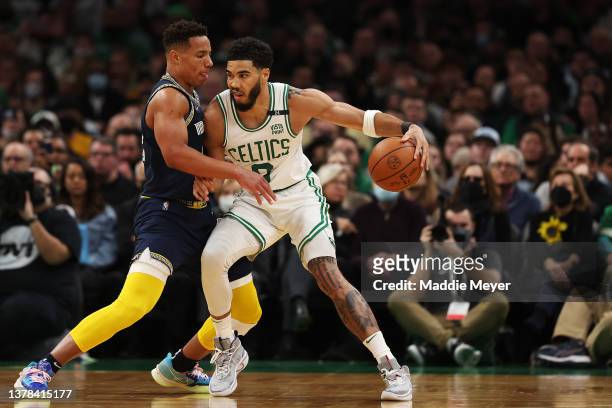 Jayson Tatum of the Boston Celtics dribbles the ball as Desmond Bane of the Memphis Grizzlies defends in the third quarter of the game at TD Garden...