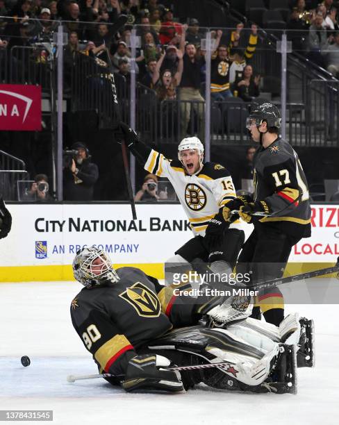 Ben Hutton of the Vegas Golden Knights looks on as Charlie Coyle of the Boston Bruins celebrates a first-period goal by teammate Craig Smith against...
