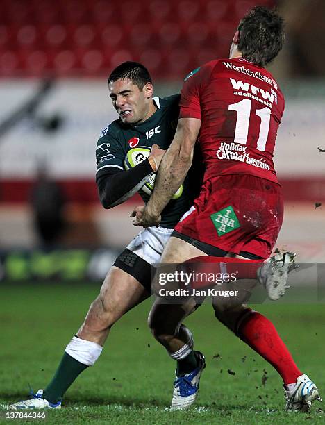 Daniel Bowden of London Irish is tackled by Andy Fenby of Scarlets during the LV= Cup match between Scarlets and London Irish at Parc y Scarlets on...